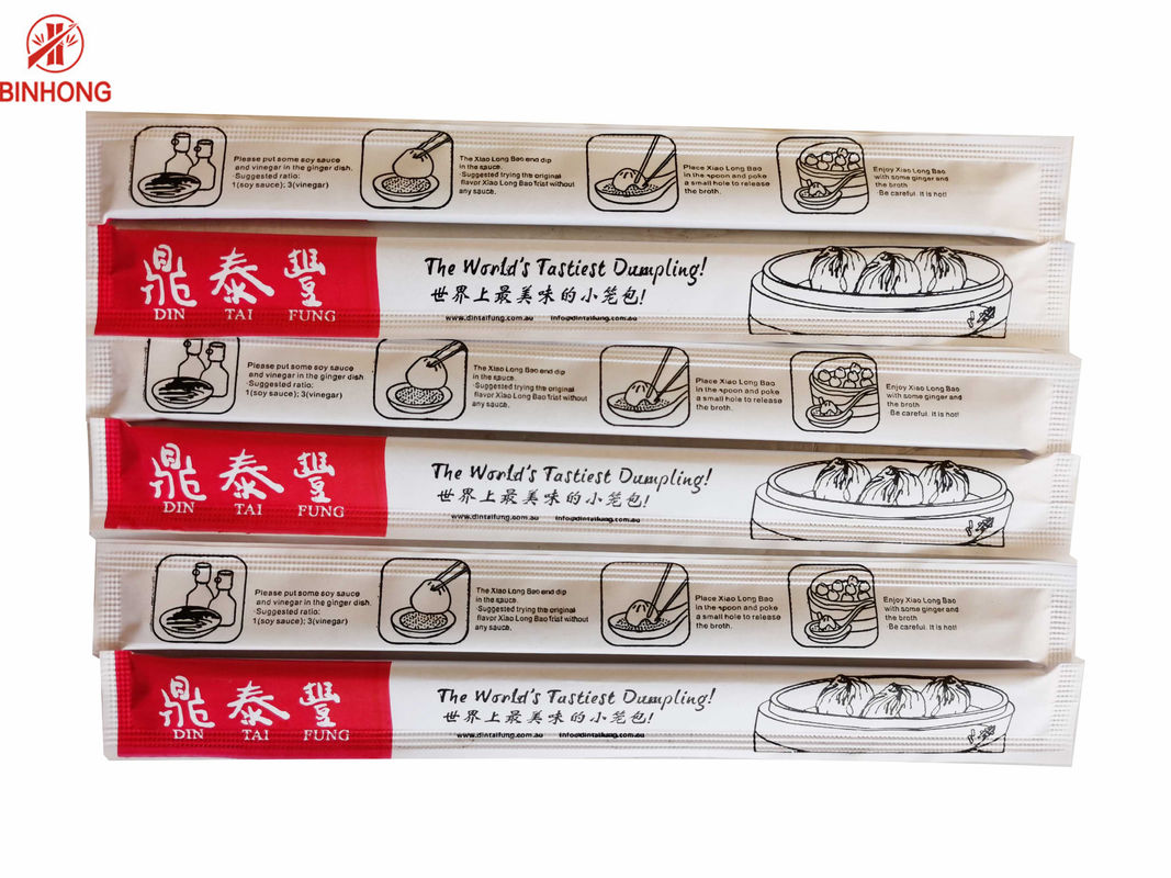 O papel envolveu os hashis descartáveis de bambu dos gêmeos biodegradáveis